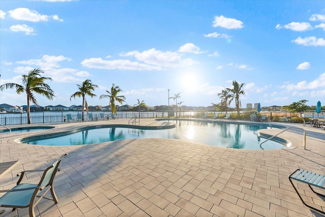 pool featuring a community hot tub, a patio area, and fence