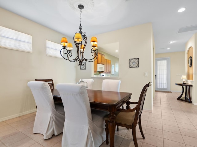 dining area featuring light tile patterned floors and a notable chandelier