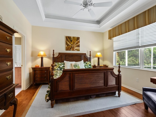 bedroom featuring hardwood / wood-style flooring, ceiling fan, and a raised ceiling