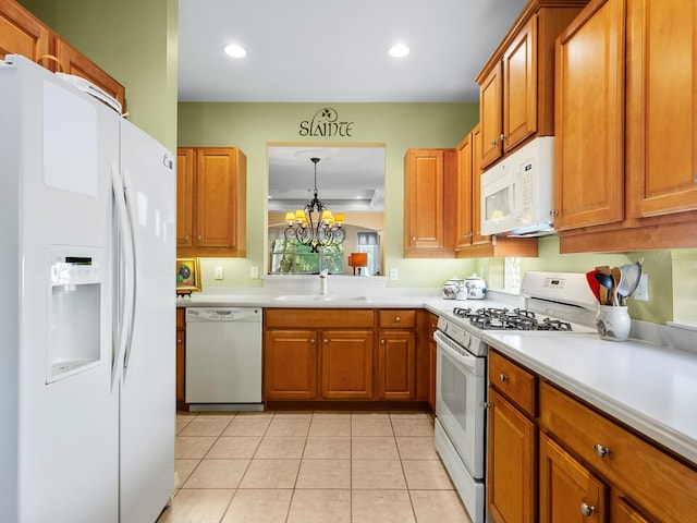 kitchen with white appliances, sink, light tile patterned floors, a chandelier, and hanging light fixtures