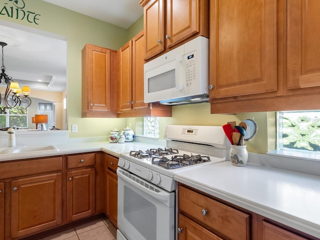 kitchen with pendant lighting, white appliances, a healthy amount of sunlight, and sink