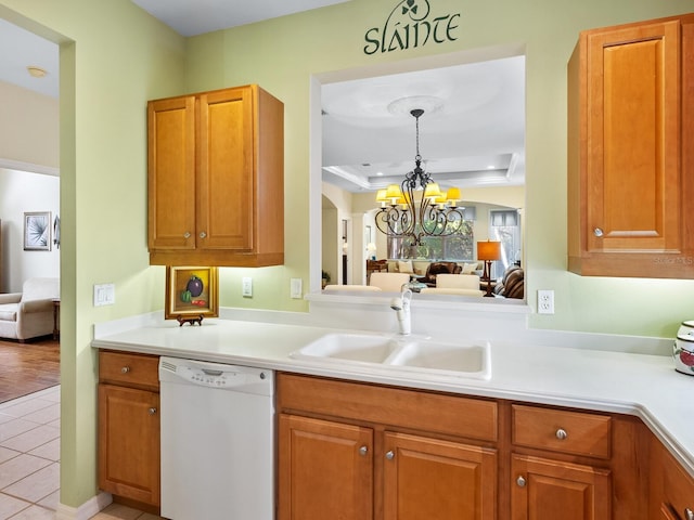 kitchen featuring dishwasher, sink, hanging light fixtures, a chandelier, and light tile patterned floors