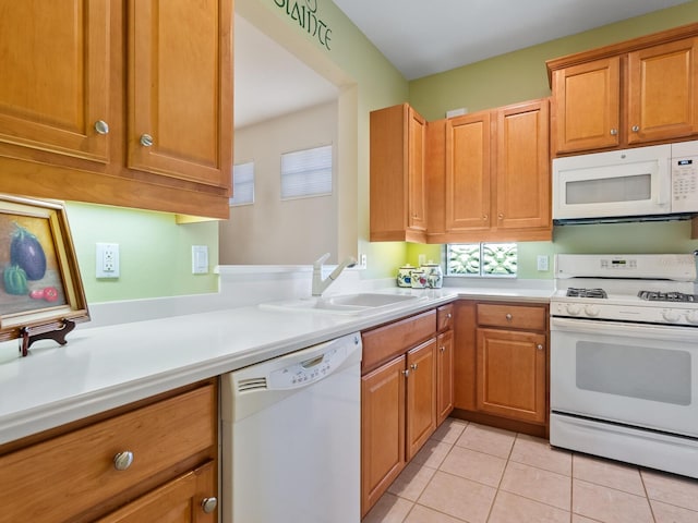 kitchen featuring white appliances, sink, and light tile patterned floors