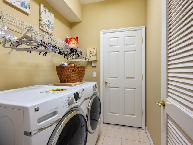 washroom with light tile patterned floors and washer and clothes dryer