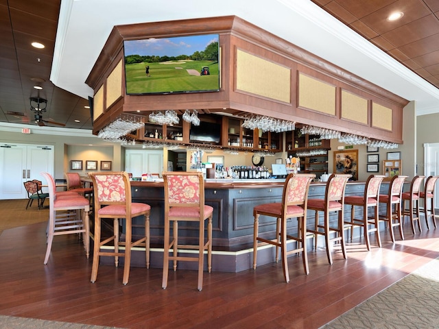 bar featuring dark hardwood / wood-style floors, ceiling fan, and ornamental molding