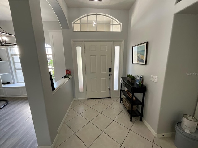 tiled entrance foyer with an inviting chandelier