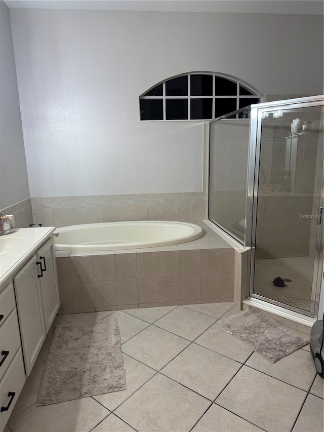 bathroom with tile patterned flooring, vanity, and shower with separate bathtub