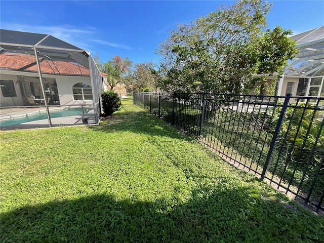 view of yard with a fenced in pool and glass enclosure