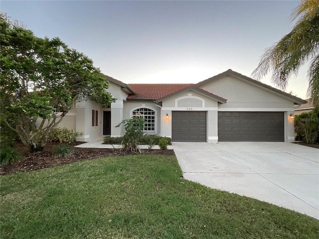 mediterranean / spanish house featuring a yard and a garage