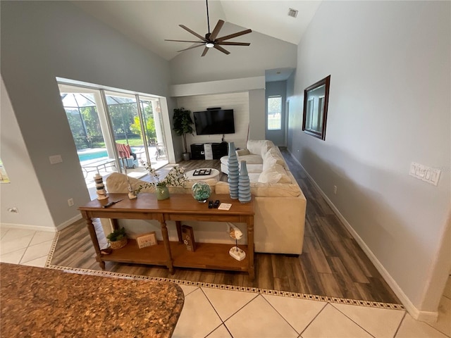 living room with hardwood / wood-style flooring, ceiling fan, and high vaulted ceiling