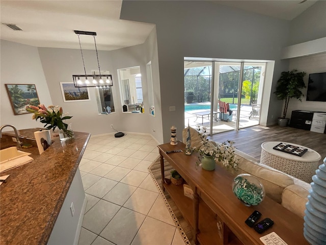 living room featuring sink, a high ceiling, and light hardwood / wood-style flooring