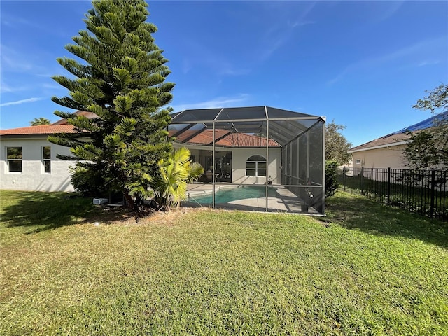 back of house with a yard, a fenced in pool, and a lanai