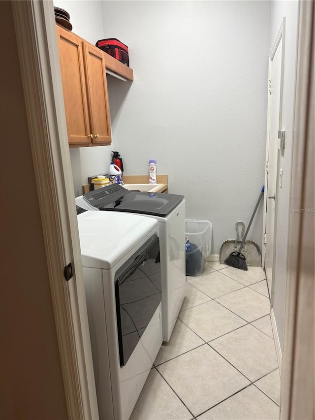 washroom featuring cabinets, independent washer and dryer, and light tile patterned flooring