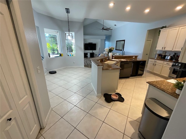 kitchen featuring white cabinets, light tile patterned floors, decorative light fixtures, and vaulted ceiling