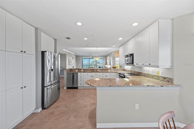 kitchen featuring kitchen peninsula, appliances with stainless steel finishes, and white cabinetry