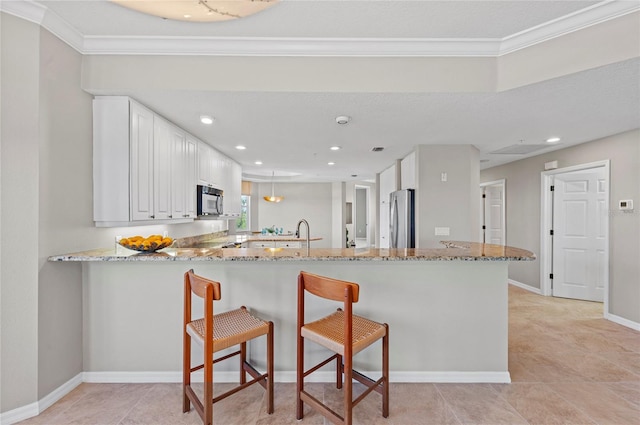 kitchen with stainless steel refrigerator, white cabinetry, kitchen peninsula, and light stone countertops