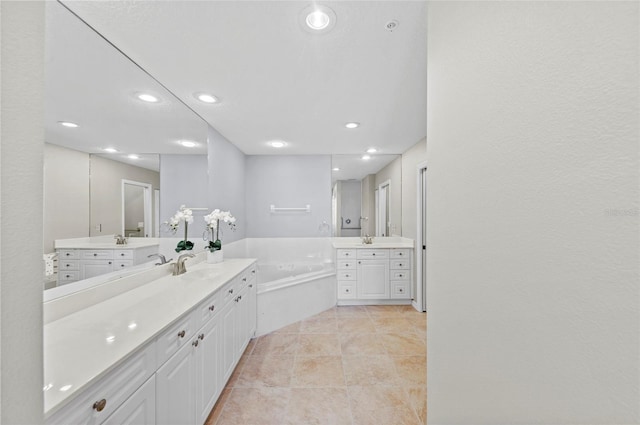 bathroom with tile patterned floors, vanity, and a tub to relax in