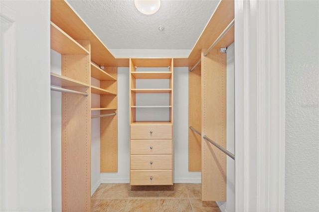 spacious closet featuring light tile patterned floors