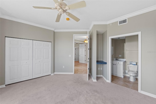 unfurnished bedroom featuring ensuite bath, light colored carpet, ceiling fan, crown molding, and sink