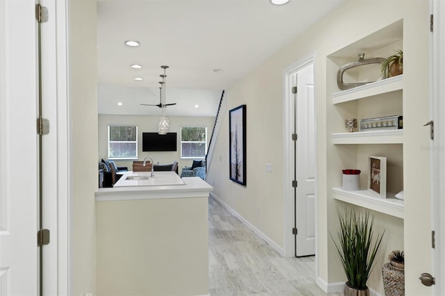 hall with sink, built in features, and light hardwood / wood-style flooring