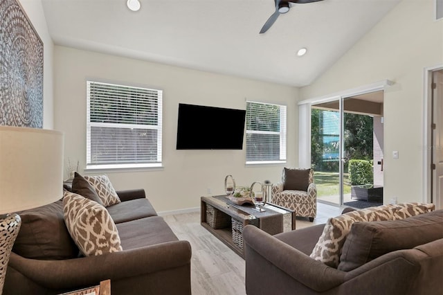 living room with ceiling fan, a wealth of natural light, light hardwood / wood-style floors, and lofted ceiling