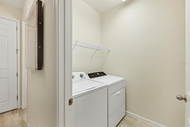 laundry area featuring washing machine and dryer and light hardwood / wood-style floors