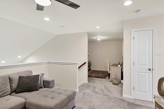 living area with light colored carpet, vaulted ceiling, and ceiling fan