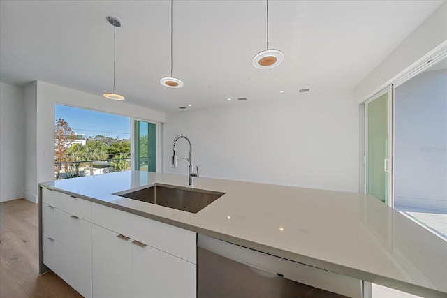 kitchen with white cabinetry, sink, dark wood-type flooring, stainless steel dishwasher, and decorative light fixtures