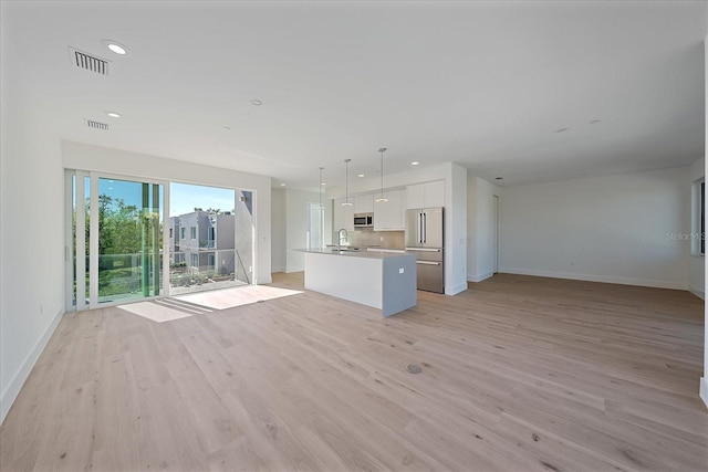 unfurnished living room with light wood-type flooring and sink