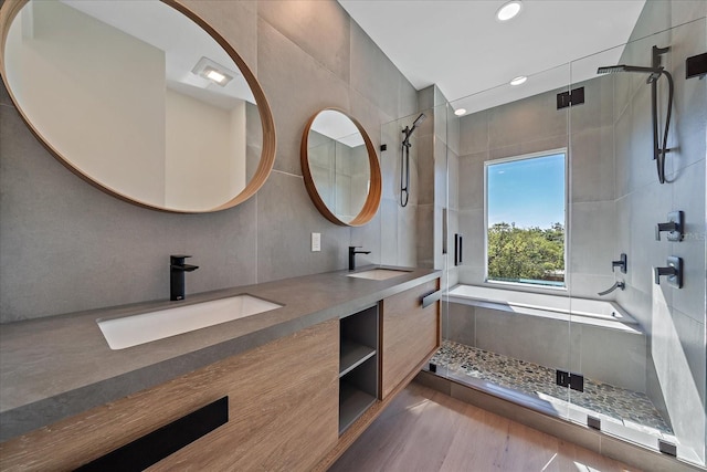 bathroom featuring vanity, decorative backsplash, shower with separate bathtub, tile walls, and wood-type flooring