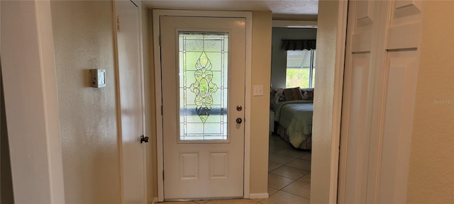 doorway to outside with light tile patterned flooring