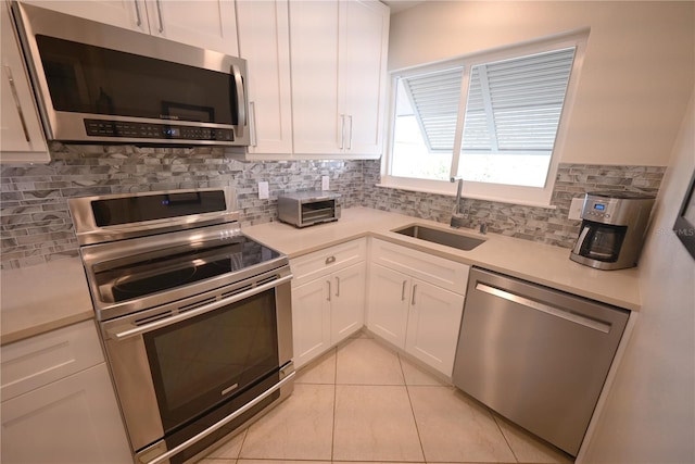 kitchen with light countertops, appliances with stainless steel finishes, and a sink