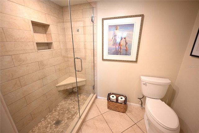 bathroom featuring a stall shower, baseboards, toilet, and tile patterned floors