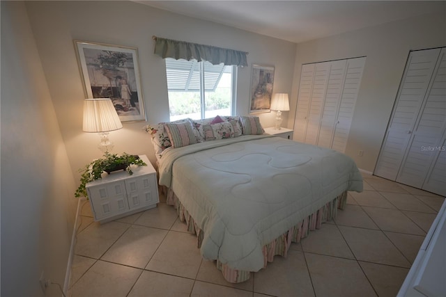 bedroom featuring multiple closets and light tile patterned flooring