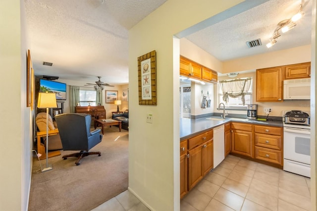 3511 Camino Real, Sarasota, FL 34239 - kitchen with white appliances, a textured ceiling, open floor plan, a ceiling fan, and brown cabinets