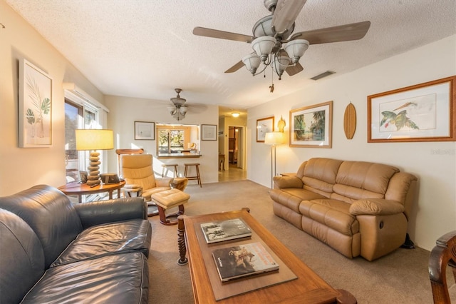 living room featuring a textured ceiling, light colored carpet, and ceiling fan