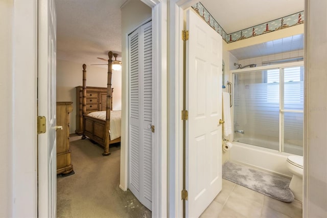 bathroom with ceiling fan, enclosed tub / shower combo, and toilet