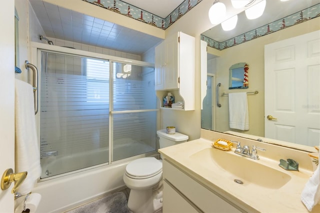 full bathroom featuring vanity, toilet, and combined bath / shower with glass door