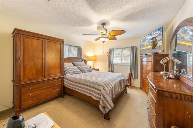 bedroom featuring ceiling fan, light colored carpet, and a textured ceiling