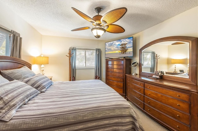 bedroom featuring carpet flooring, a textured ceiling, and ceiling fan