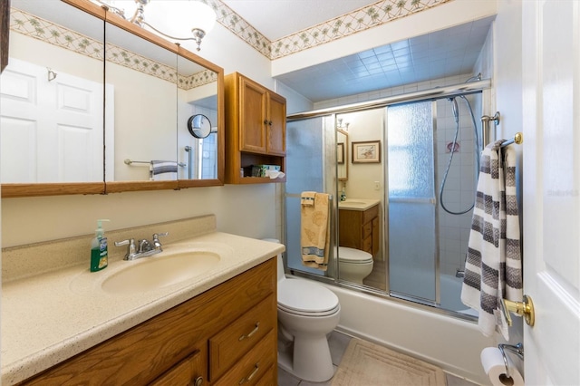 full bathroom featuring toilet, vanity, and combined bath / shower with glass door