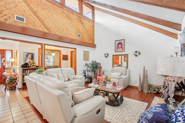 living room featuring ceiling fan, beamed ceiling, high vaulted ceiling, and light tile patterned floors