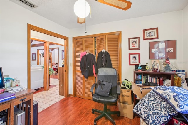 bedroom with ceiling fan, light hardwood / wood-style floors, and a closet