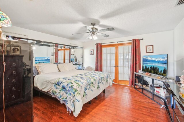 bedroom featuring ceiling fan, french doors, wood-type flooring, and a textured ceiling