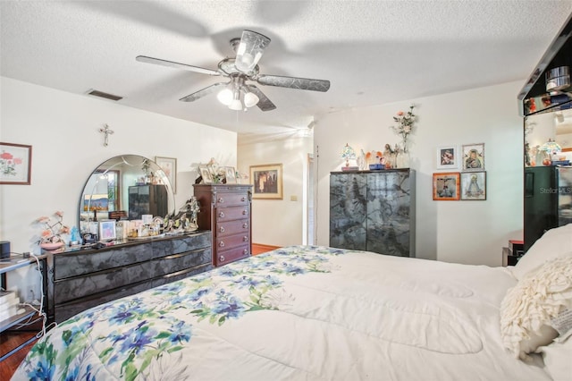 bedroom featuring wood-type flooring, a textured ceiling, and ceiling fan