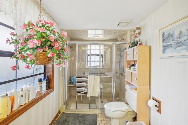 bathroom featuring tile patterned flooring, toilet, and a shower with door