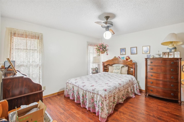 bedroom with a textured ceiling, dark hardwood / wood-style floors, and ceiling fan