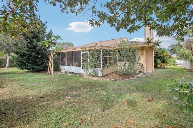 view of side of home featuring a sunroom and a yard