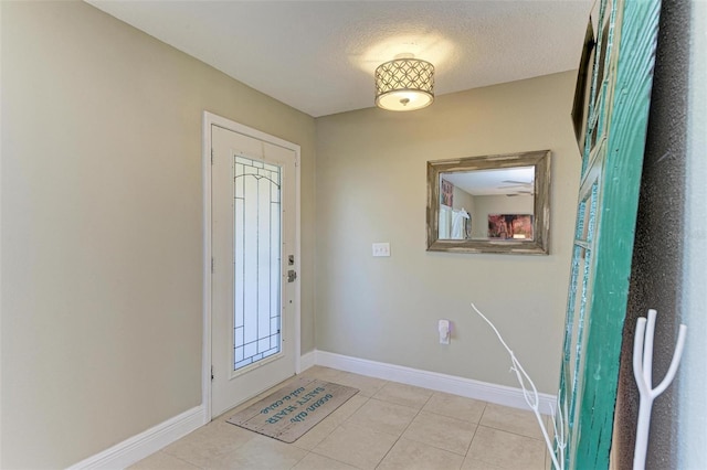 entryway featuring light tile patterned floors and a textured ceiling