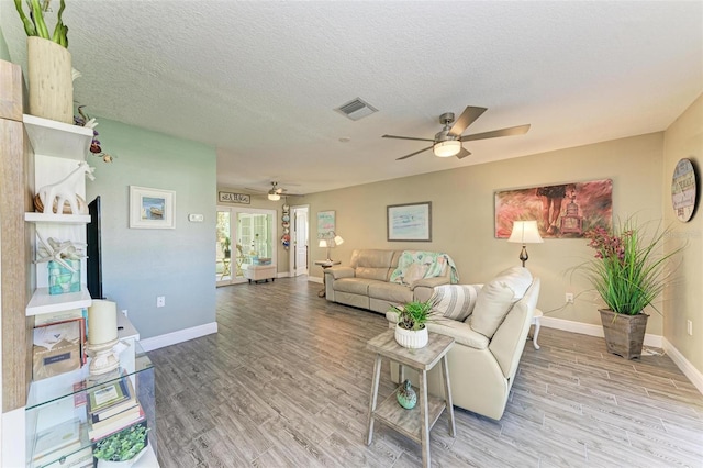 living room featuring hardwood / wood-style floors, a textured ceiling, and ceiling fan